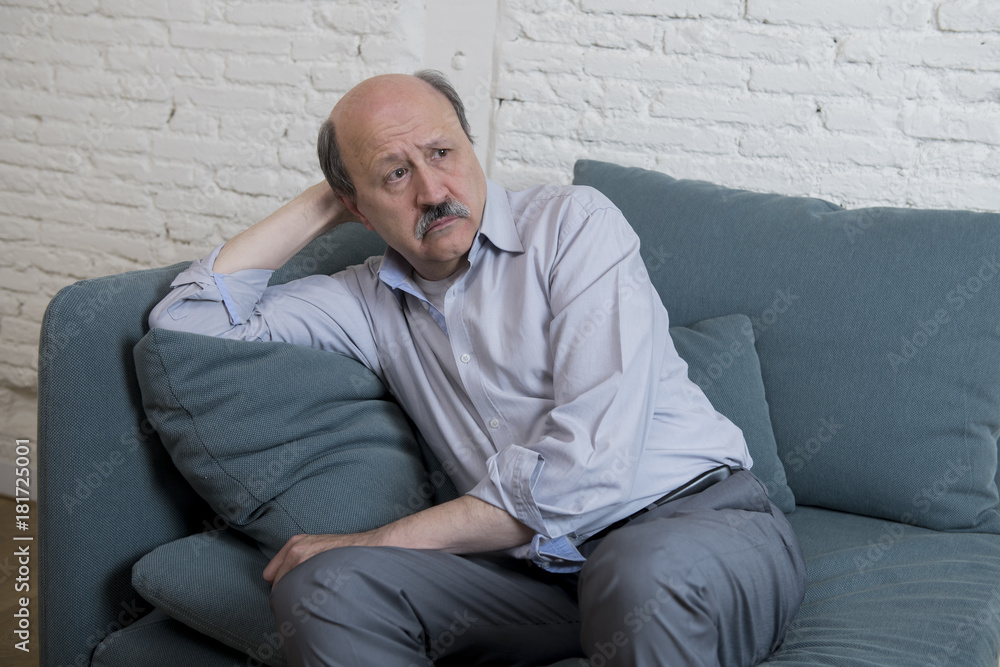 portrait of senior mature old man on his 60s at home couch alone feeling sad and worried suffering pain and depression portrait of senior mature old man on his 60s at home couch alone feeling sad and worried suffering pain and depression
