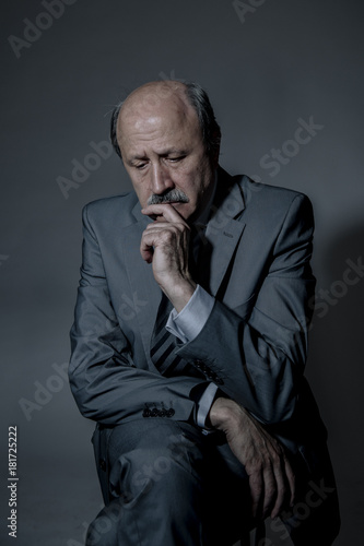 portrait of sad and depressed senior mature business man on his 60s suffering depression looking lost and thoughtful wearing necktie