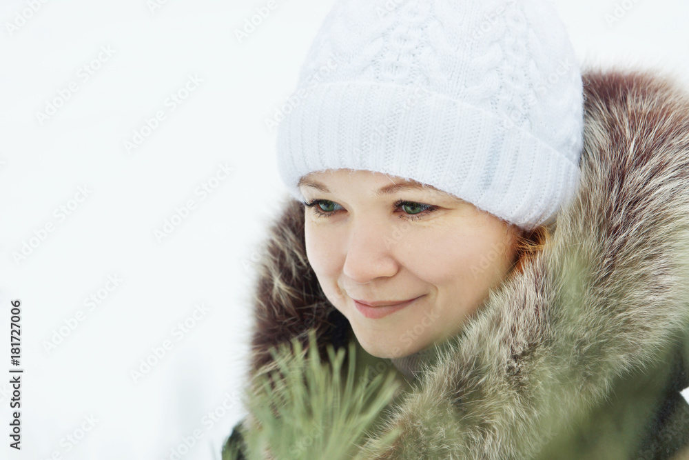 Young pretty woman wearing white knitted hat in a winter park outdoors Young pretty woman wearing white knitted hat in a winter park outdoors