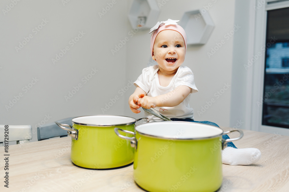 Ñute baby girl in the kitchen playing with pans Ñute baby girl in the kitchen playing with pans