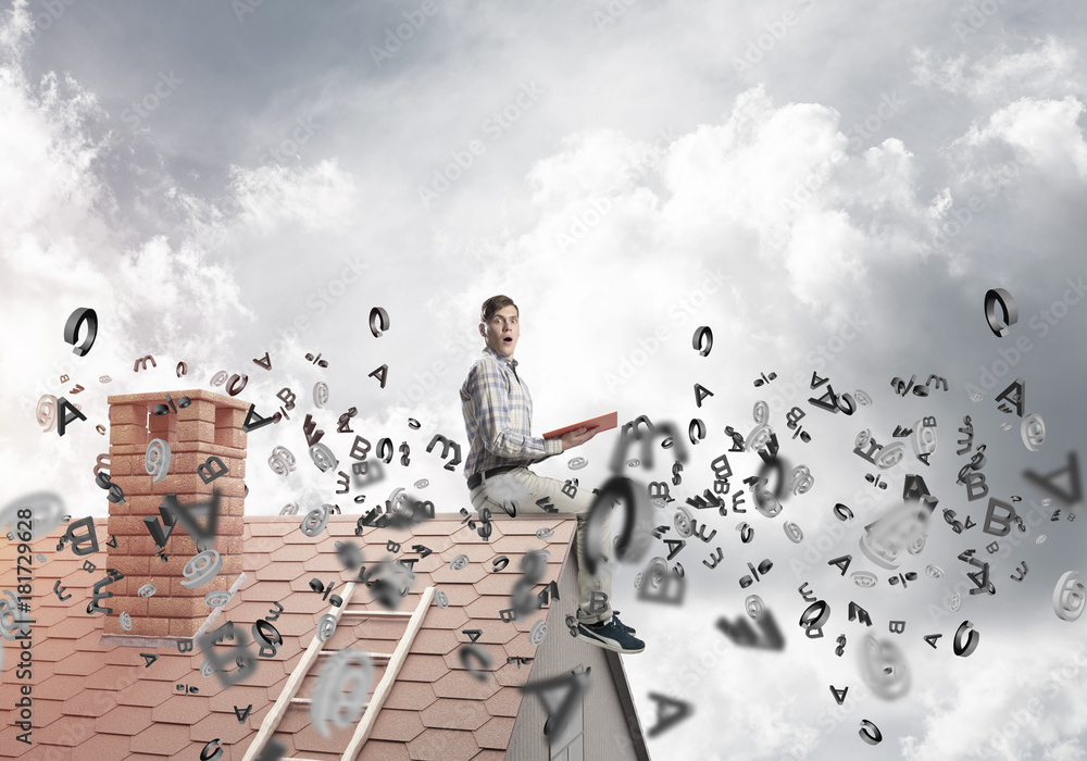Man on brick roof reading book and symbols flying around Man on brick roof reading book and symbols flying around