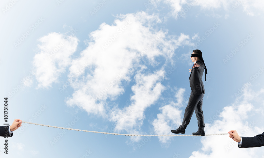 Business concept of risk support and assistance with man balancing on rope Business concept of risk support and assistance with man balancing on rope