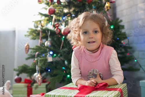 Girl playing in the room with a Christmas tree