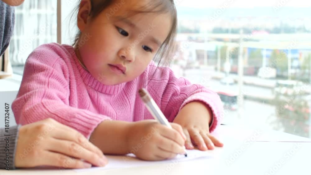 little girl doing homework study indoor by the window little girl doing homework study indoor by the window