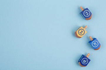 Blue background with multicolor dreidels. Hanukkah and judaic holiday concept.
