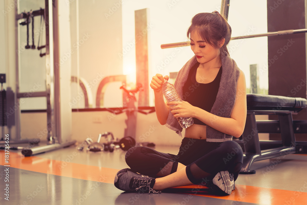 Woman exercise workout in gym fitness breaking relax open water recovery after training sport with dumbbell and protein shake bottle healthy lifestyle bodybuilding. Woman exercise workout in gym fitness breaking relax open water recovery after training sport with dumbbell and protein shake bottle healthy lifestyle bodybuilding.