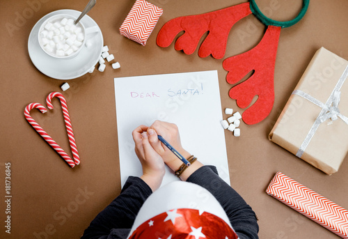 Cocoa with marshmallow and Boy writing letter to Santa Claus at Christmas. Top view.