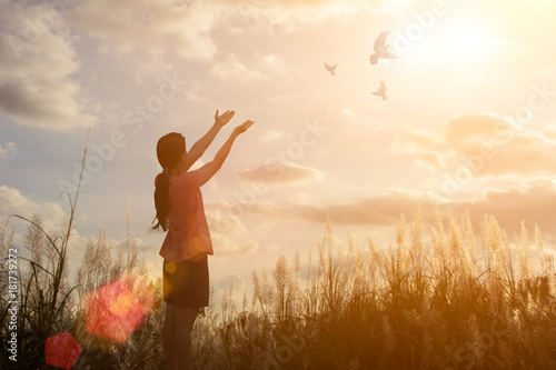 Freedom concept: Silhouette woman hand broken chains and praying against sunset.