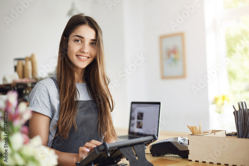 Fotografi Portrait of young beautiful woman running a pastry shop owning a business waking up early to greet her customers with a smile