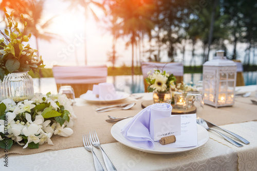Romantic dinner setting at pool with sunset on the beach