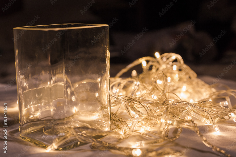 glass cup with LED light bulb wire in background glass cup with LED light bulb wire in background