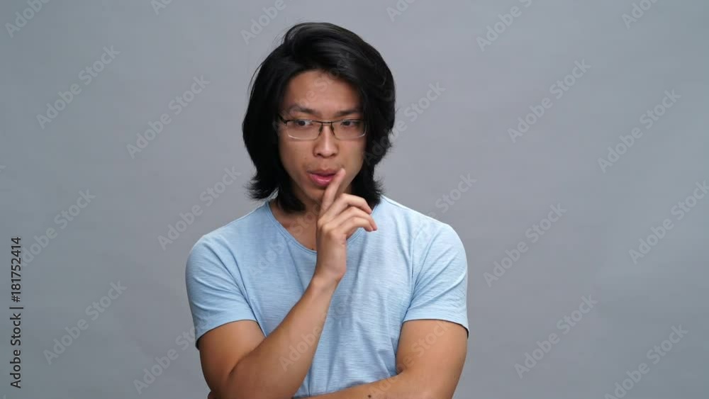 Handsome smiling young asian man thinking something and have an idea isolated Handsome smiling young asian man thinking something and have an idea isolated