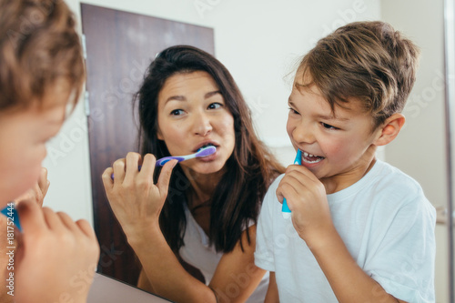 Bilde på lerret Mother and son brushing teeth in bathroom