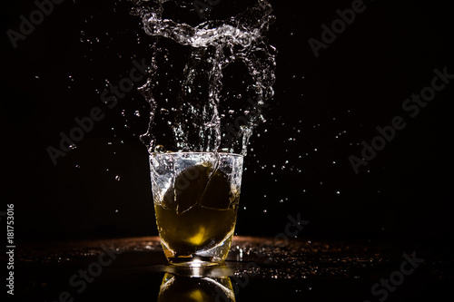 Lemon dropped in a glass of watter and frozen with a flash