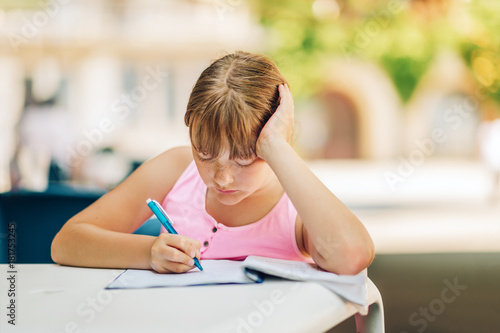 Cute kid girl doing school homework outside, home schooling, education for children, back to school concept