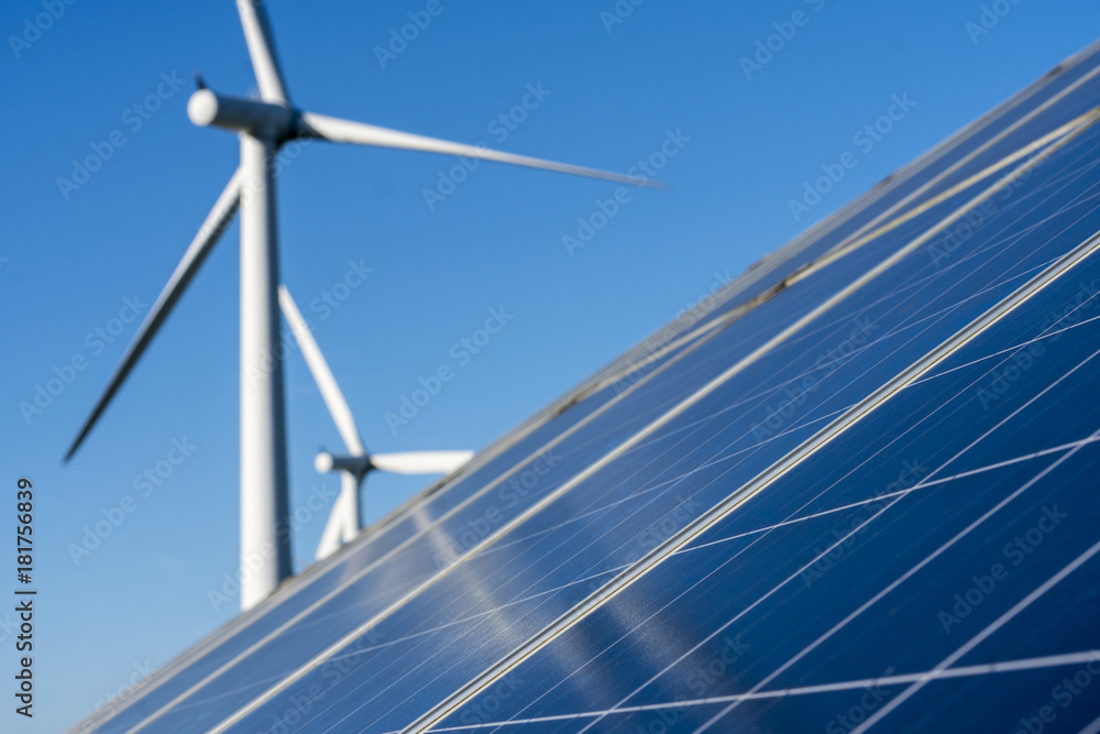 Solar panels and wind turbine on a clear blue sky day Solar panels and wind turbine on a clear blue sky day