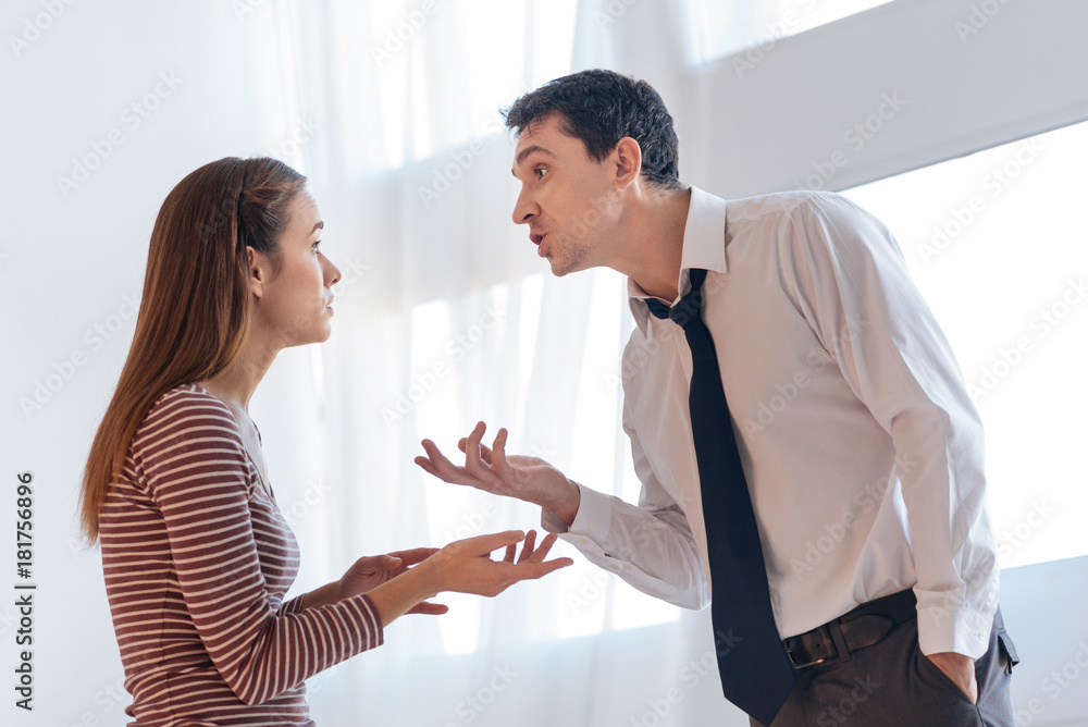Misunderstanding. Emotional angry irritated man looking expressive while explaining his point of view to his upset wife
