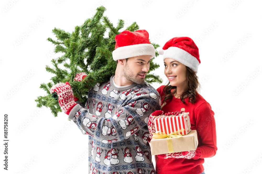 couple carrying christmas tree and gifts couple carrying christmas tree and gifts