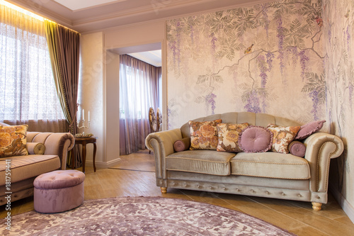 Living room with soft sofa, wallpaper with grapes and purple carpet