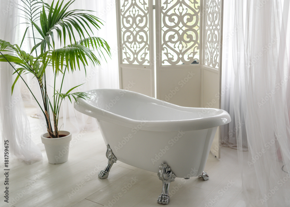 Beautiful luxury vintage empty bathtub near big window in bathroom