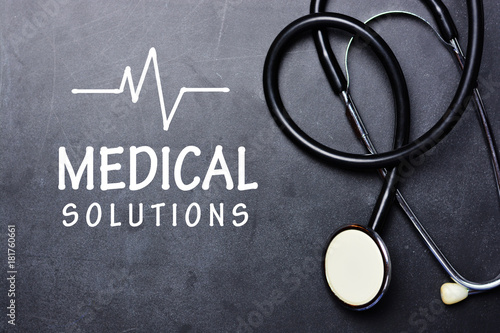 Medical solutions text on chalkboard with stethoscope in the right side