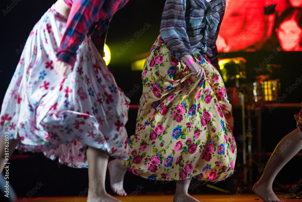 Naklejka premium Young dancer woman barefoot in gypsy dress dancing on stage
