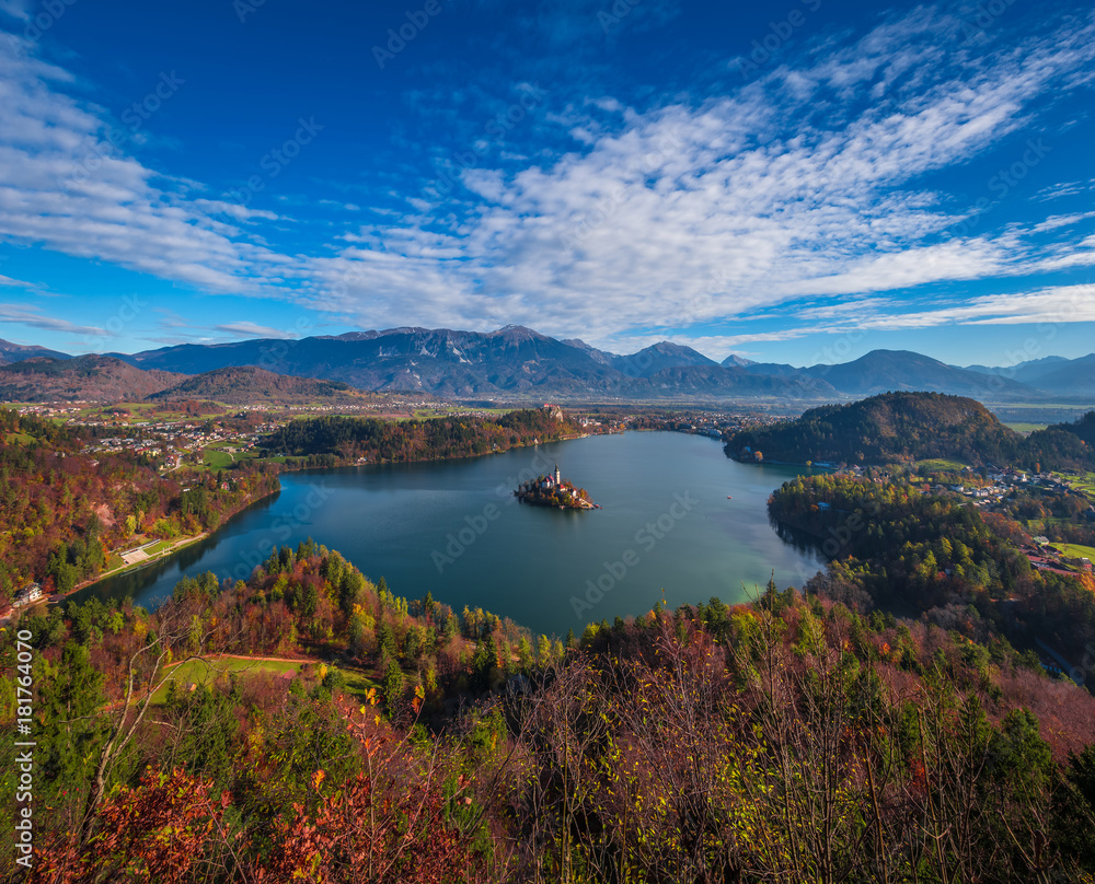 Bled, Slovenia - Panoramic skyline view of Lake Bled from Ojstrica viewpoint with famous Pilgrimage Church of the Assumption of Maria, traditional Pletna boats and Bled Castle at background at autumn