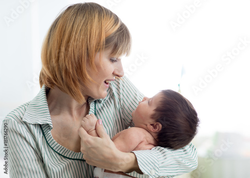 mom looking at infant baby in nursery