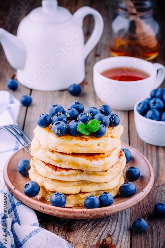 Delicious pancakes with fresh blueberries and honey