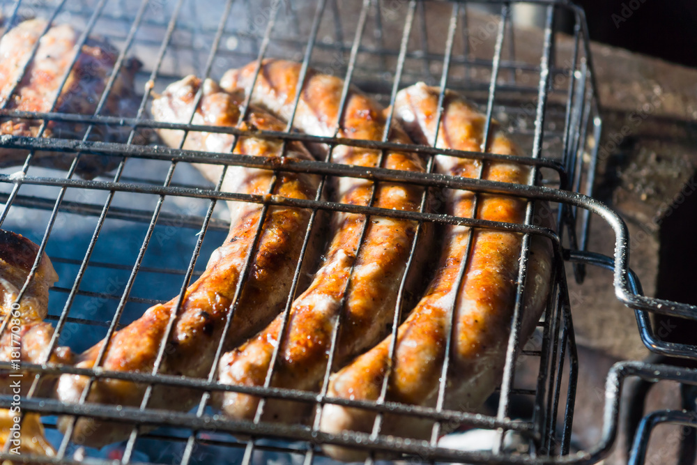 Pork sausages are fried on the grill at night, close-ups