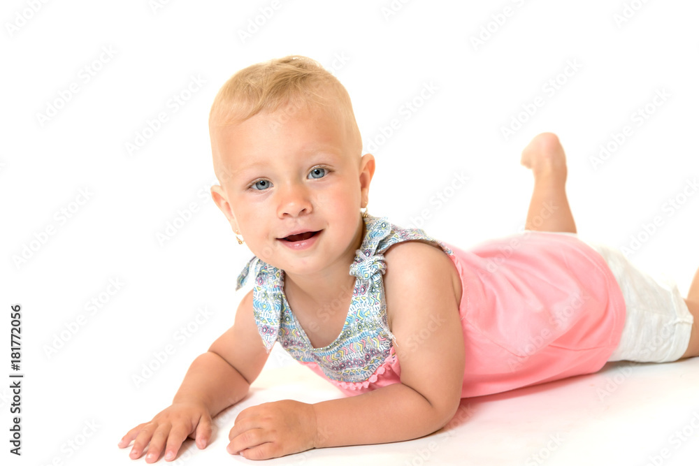 Smiling toddler girl is lying on a floor Smiling toddler girl is lying on a floor