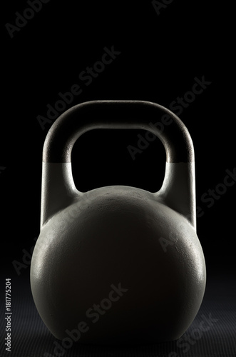 Fototapeta Naklejka Na Ścianę i Meble -  Backlit competition kettlebell silhouette on a black background with text / writing / copy space on and above kettlebell