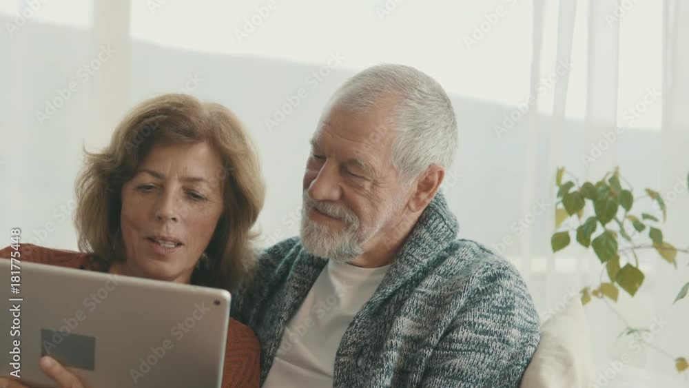 Senior couple with tablet relaxing at home. Senior couple with tablet relaxing at home.