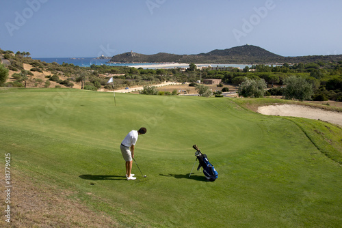 man playing golf on green course photo