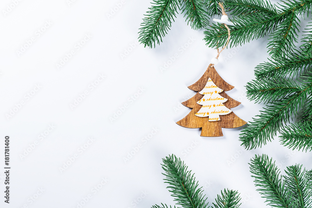 Christmas frame with the branches of the Christmas tree and wooden decorations on white background. Simple Christmas composition with free space Christmas frame with the branches of the Christmas tree and wooden decorations on white background. Simple Christmas composition with free space