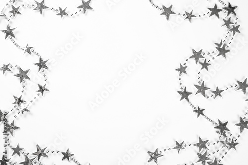 Christmas frame with silver stars decorations on white background. Simple Christmas composition with free space