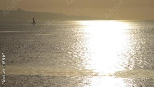 barca a vela naviga sul mare piatto e luccicante del mattino photo