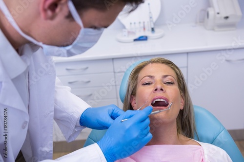 Doctor giving dental treatment to woman at clinic