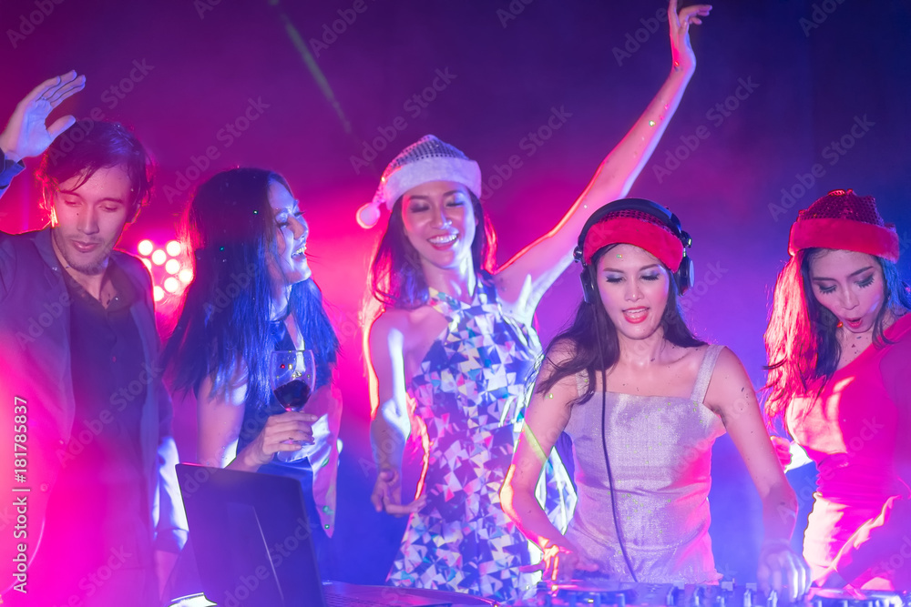 Portrait of active pretty young DJ woman playing music on laser lighting background Portrait of active pretty young DJ woman playing music on laser lighting background