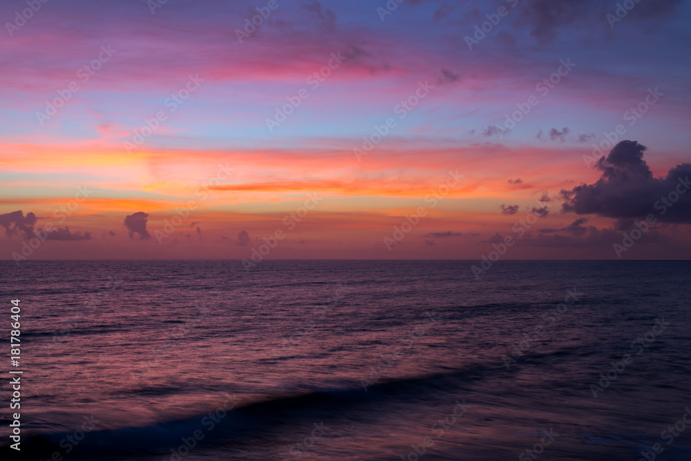 Dramatic pink sunset clouds over water sea. Seascape landscape at dusk