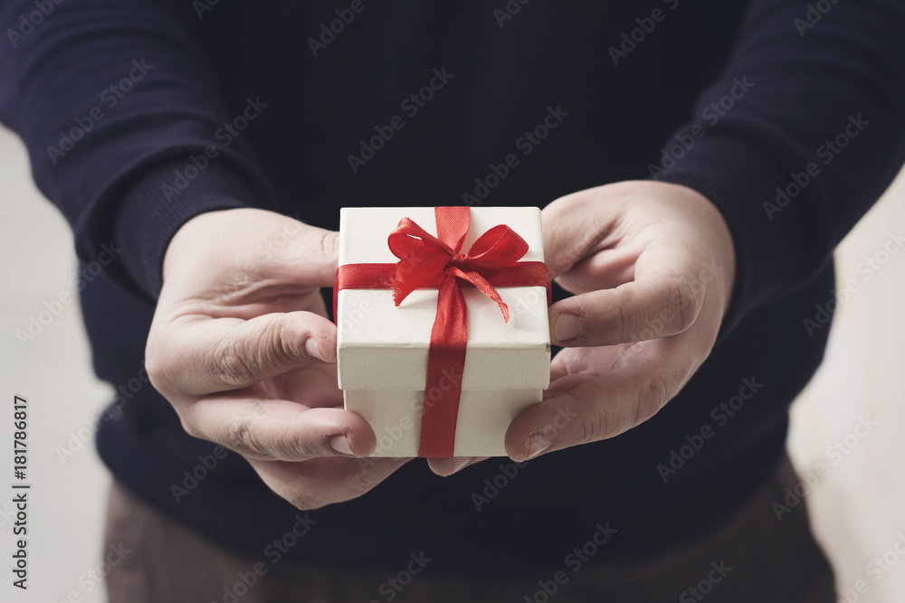 A man holding a gift box in his hands A man holding a gift box in his hands