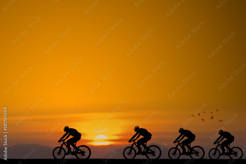 Obraz premium Silhouette of cyclist with friend on the background of beautiful sunset
