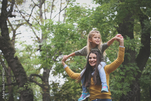 Mother carrying daughter on shoulders.