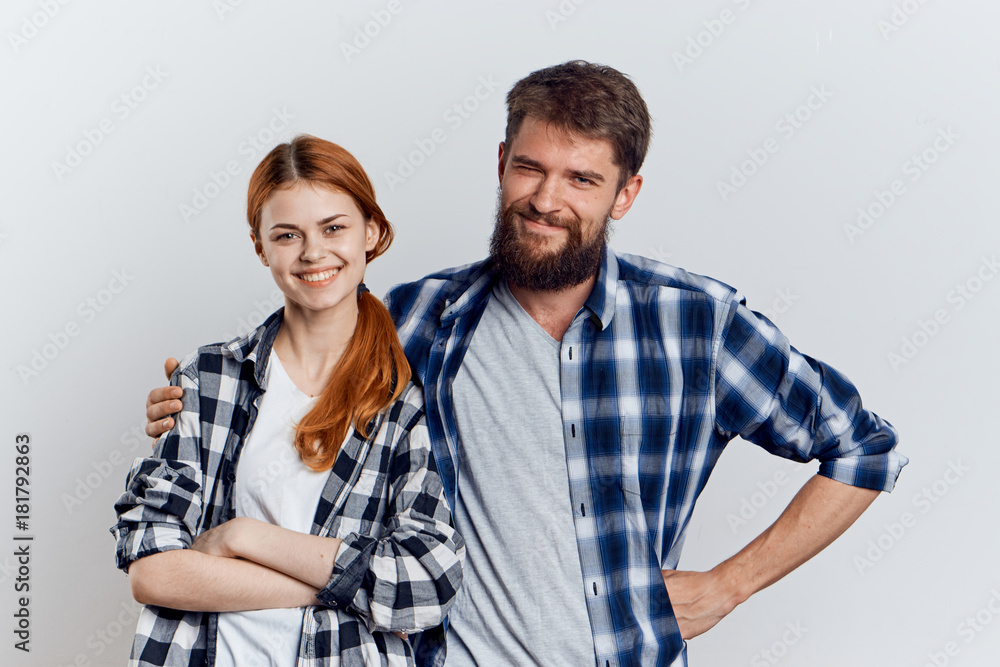 Beautiful young woman on a light background with a bearded man, relationship, friendship Beautiful young woman on a light background with a bearded man, relationship, friendship