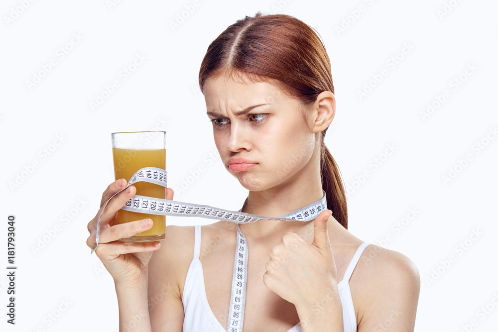 Beautiful young woman on white isolated background holds a glass of orange juice, diet, fitness, health Beautiful young woman on white isolated background holds a glass of orange juice, diet, fitness, health