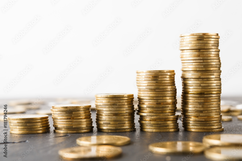 Increasing columns of gold coins on table Increasing columns of gold coins on table