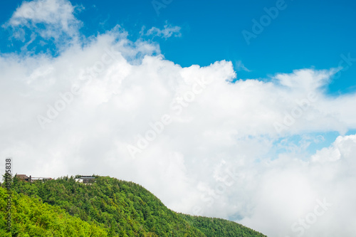 building the the mountain among clouds and blue sky. Green mountain and the cloud and bright blue sky at fuji mountain in Japan. Good for holidays and summer for hiking to the top of renown mt. fuji.