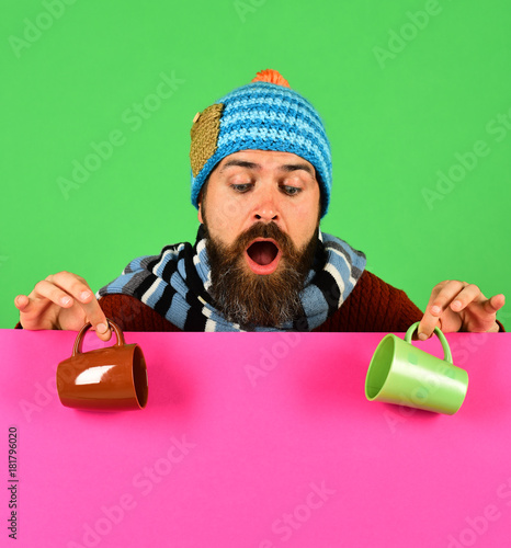 Hipster with beard and surprised face has coffee