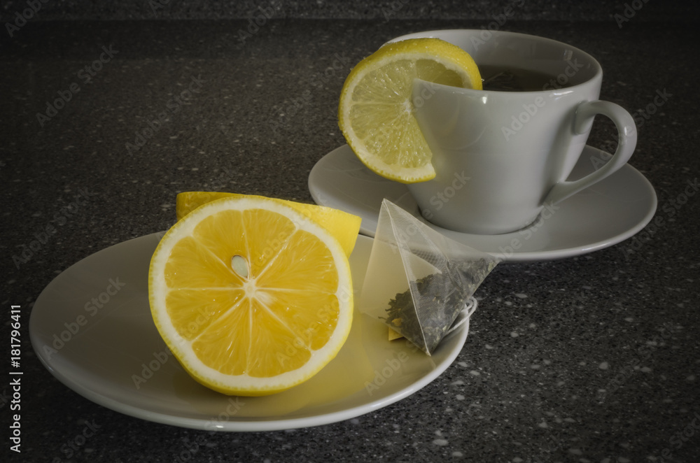 A cup of tea with lemon and tea bag on a granite table A cup of tea with lemon and tea bag on a granite table