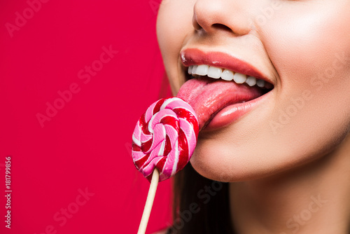 woman licking colored lollipop